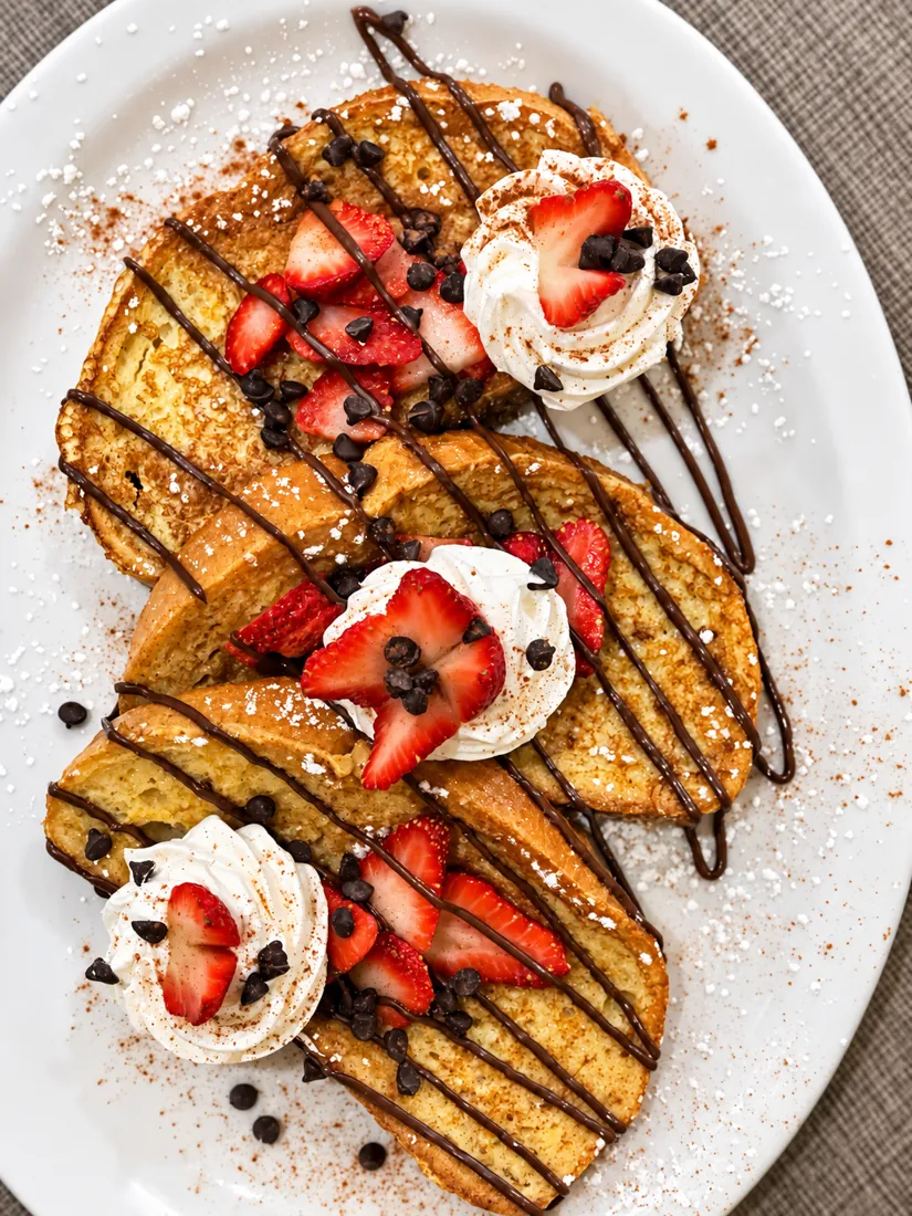French toast with strawberries, chocolate drizzle and whipped cream