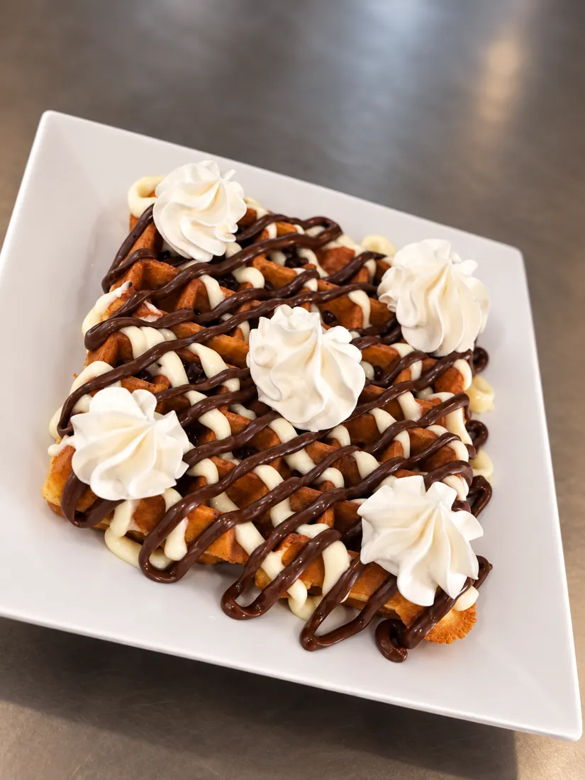 Waffle with chocolate drizzle and whipped cream